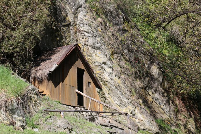 A restored miners’ hut beside the hillside at Arrowtown’s Chinese Settlement