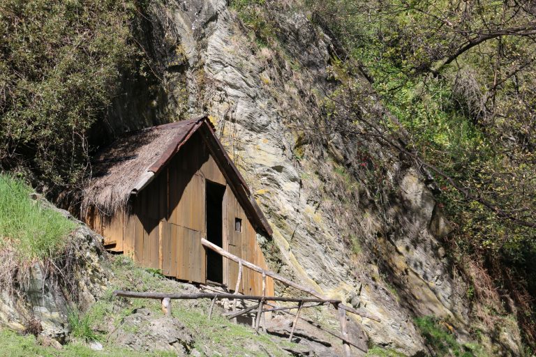 A restored miners’ hut beside the hillside at Arrowtown’s Chinese Settlement