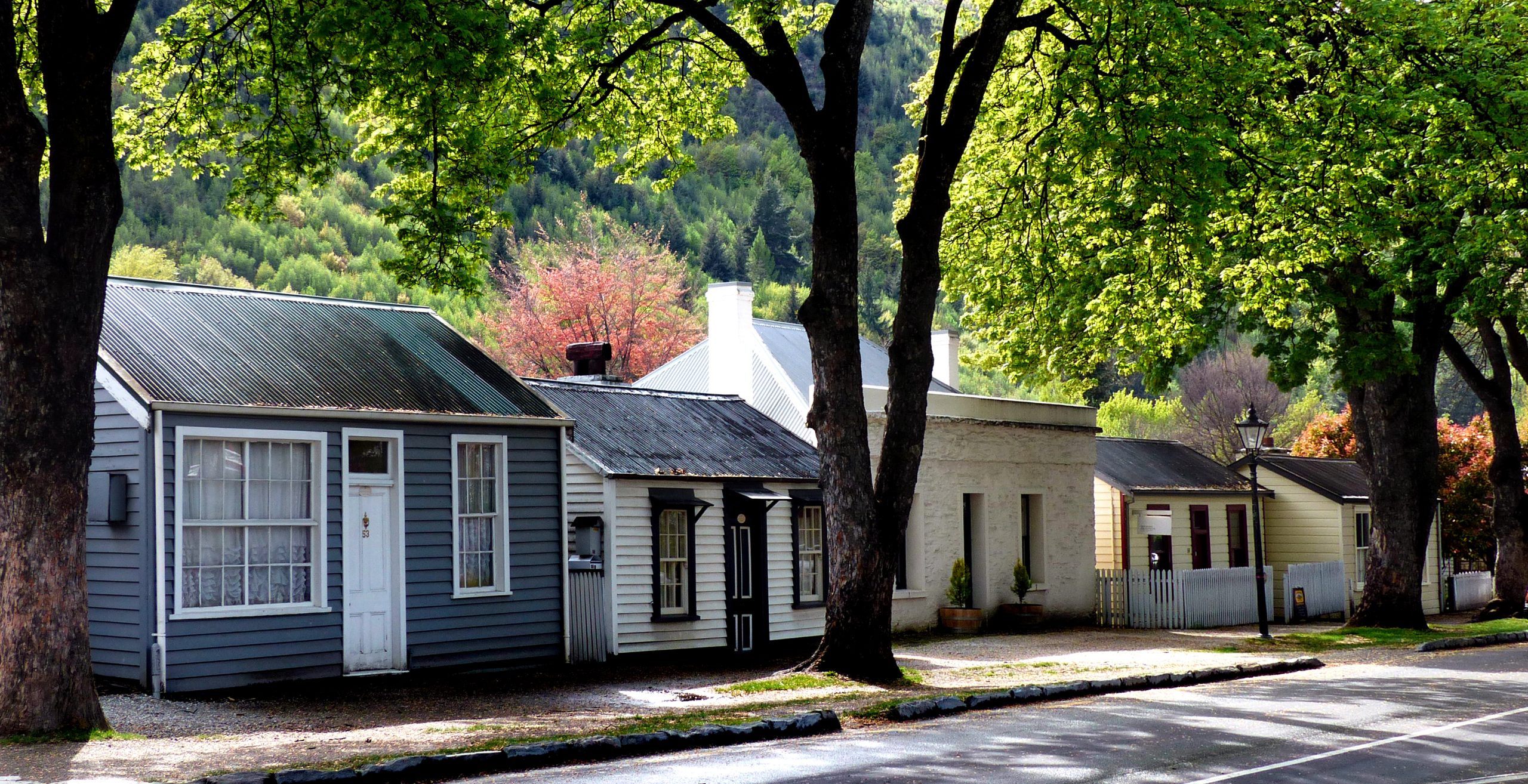 Historic street buildings in Arrowtown with the surrounding hills beyond