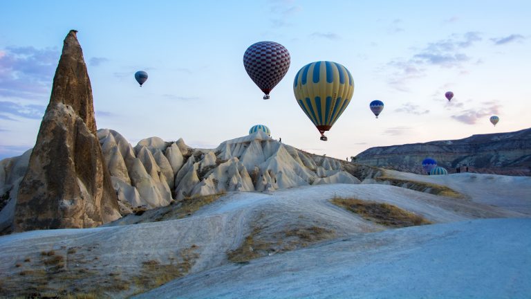 Hot air balloons above Cappadocia’s eroded rock formations at sunrise